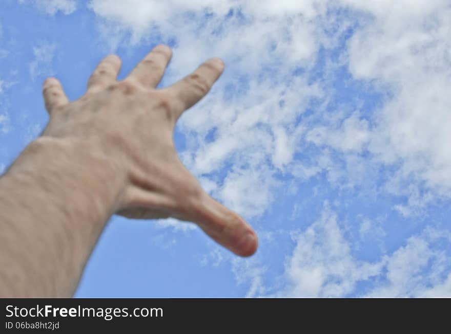 Hand stretched to the blue cloudy sky. Hand stretched to the blue cloudy sky