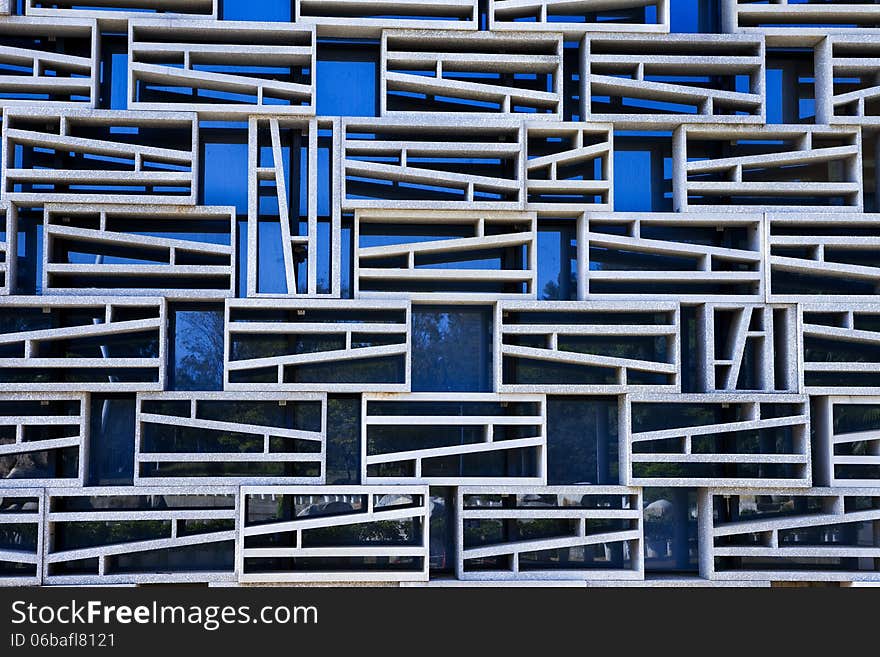 Wall facade with geometric granite grids and blue galsses. Wall facade with geometric granite grids and blue galsses