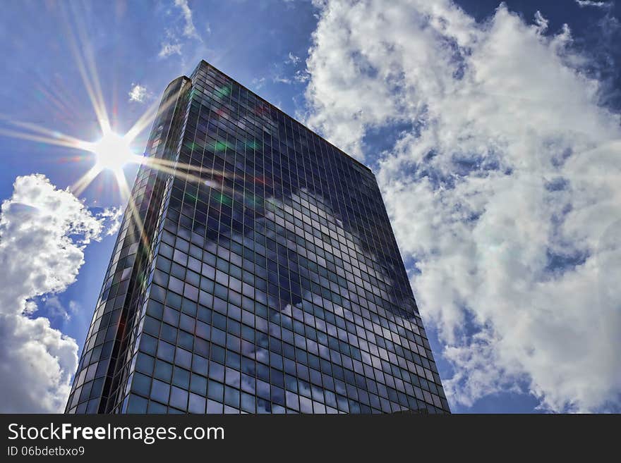 Glass skyscraper on the background of sky and sun. Glass skyscraper on the background of sky and sun