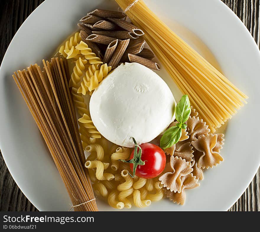 Raw pasta with basil, mozzarellal and tomato overhead shoot