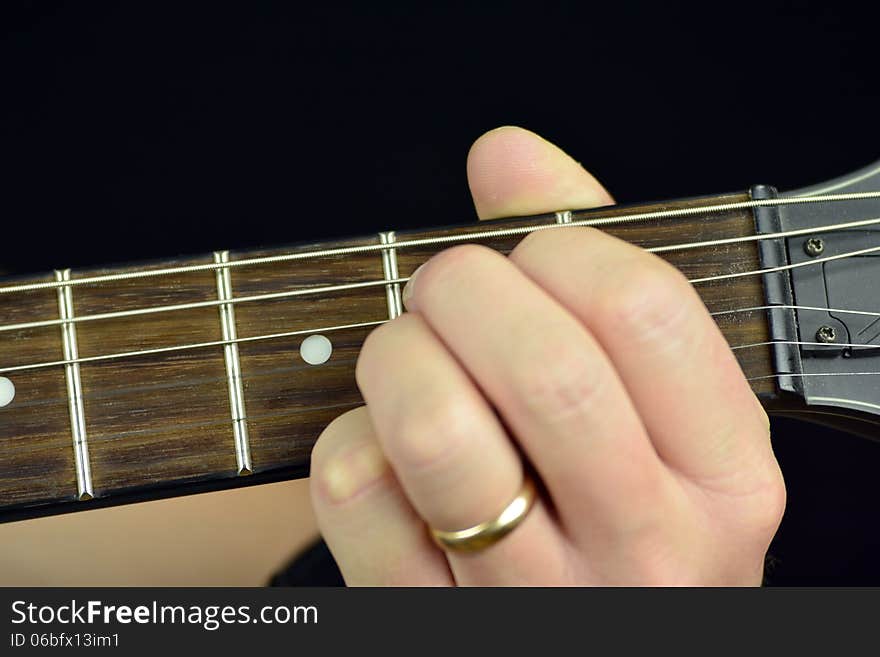 Hand, hold a chord on the guitar fretboard