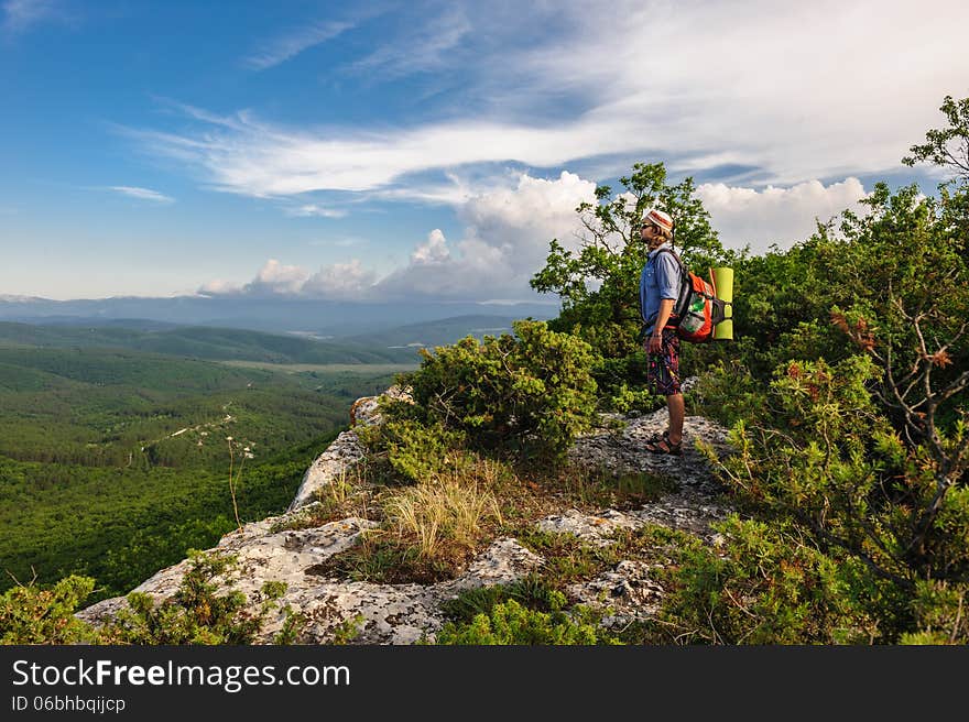 Hiking man in rays of sunset