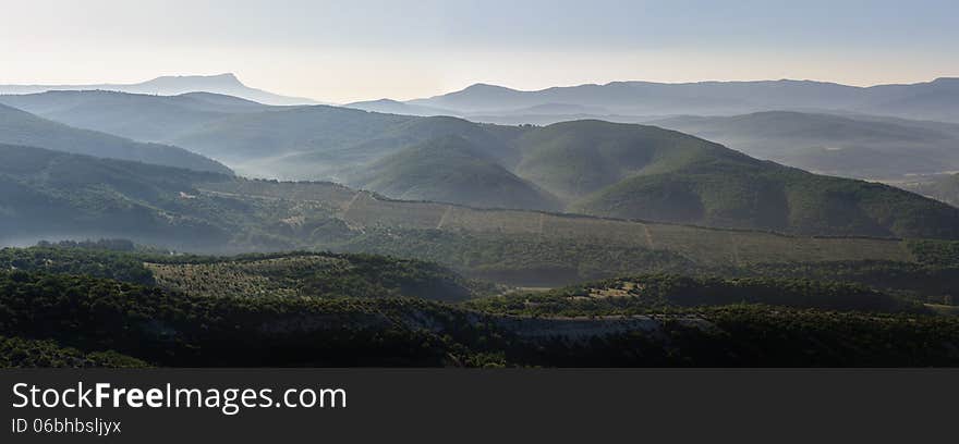 Landscape, sunrise over foggy hills, panorama stitched from 3 frames