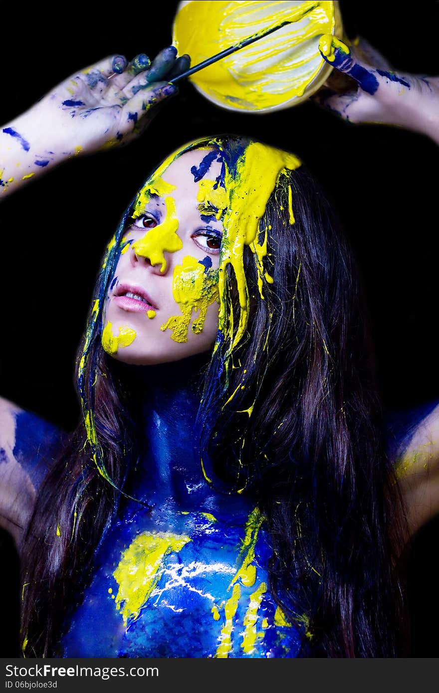 Beauty/fashion Close Up Portrait Of Woman Painted Blue And Yellow With Brushes And Paint  On Black Background