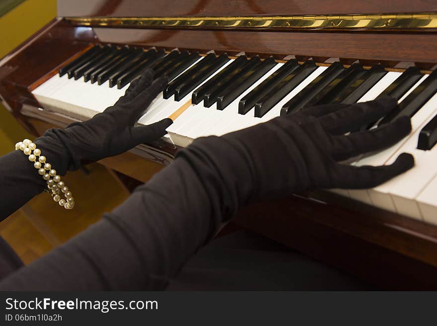 A classy woman in vintage gloves playing piano. A classy woman in vintage gloves playing piano