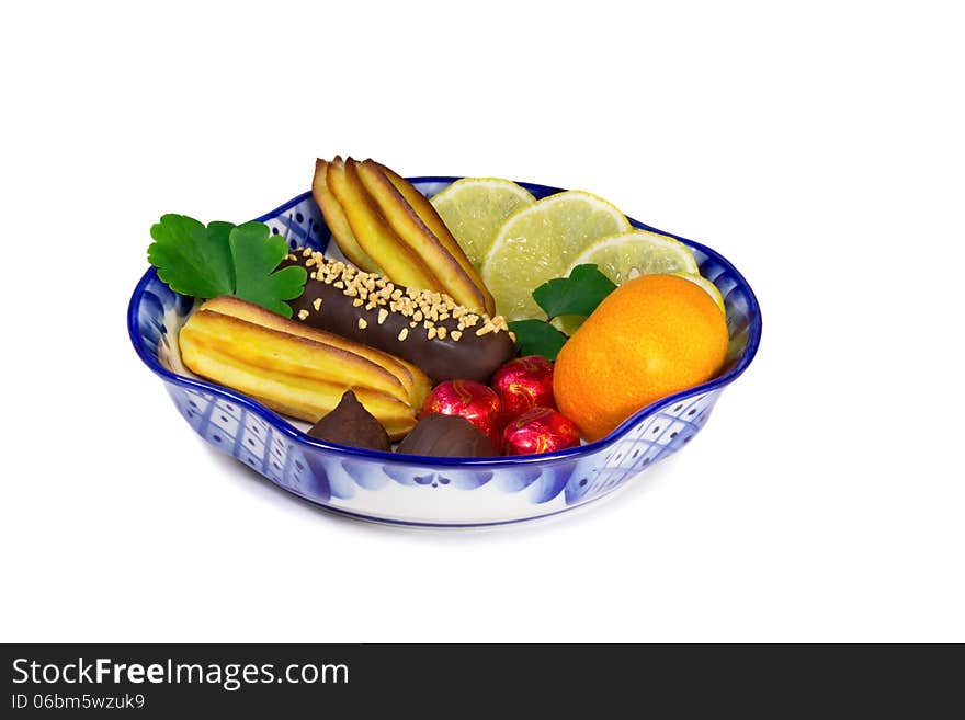 Vase filled with cakes, sweets, fruits. Painted blue pattern in the style of the "Gzhel" and presents on a white background. Vase filled with cakes, sweets, fruits. Painted blue pattern in the style of the "Gzhel" and presents on a white background.