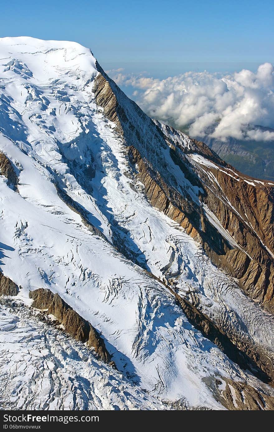 Mountain peak covered with snow higher than clouds, swiss alps