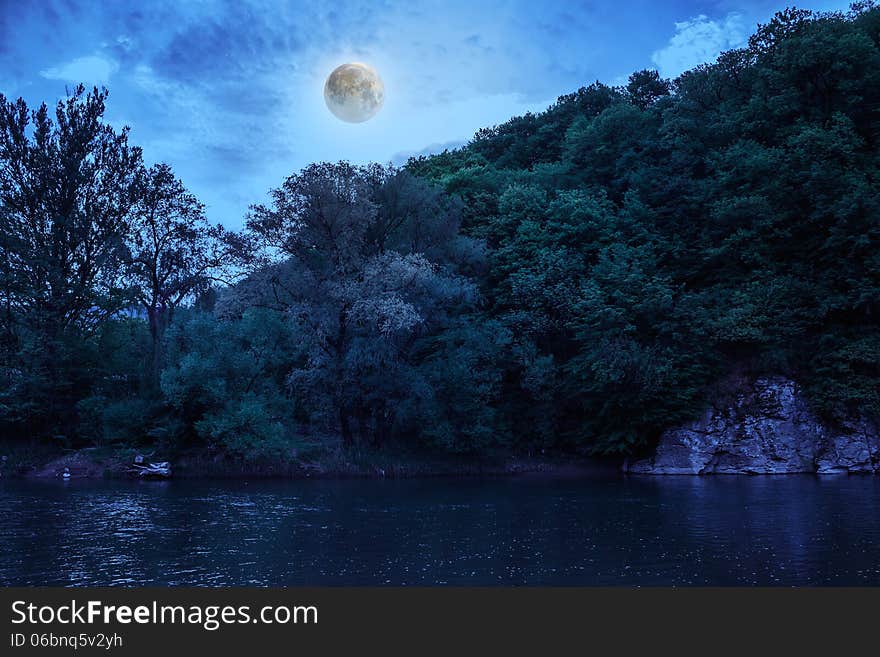 Wild river flowing between green mountains on a clear summer night. Wild river flowing between green mountains on a clear summer night