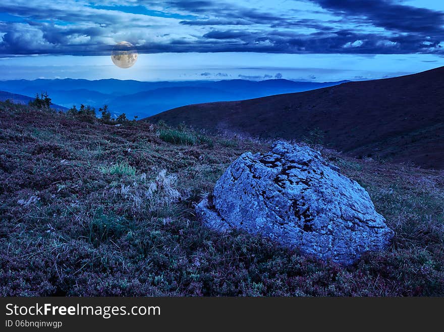 Mountain panorama with large rock in grass on the hillside at night. Mountain panorama with large rock in grass on the hillside at night