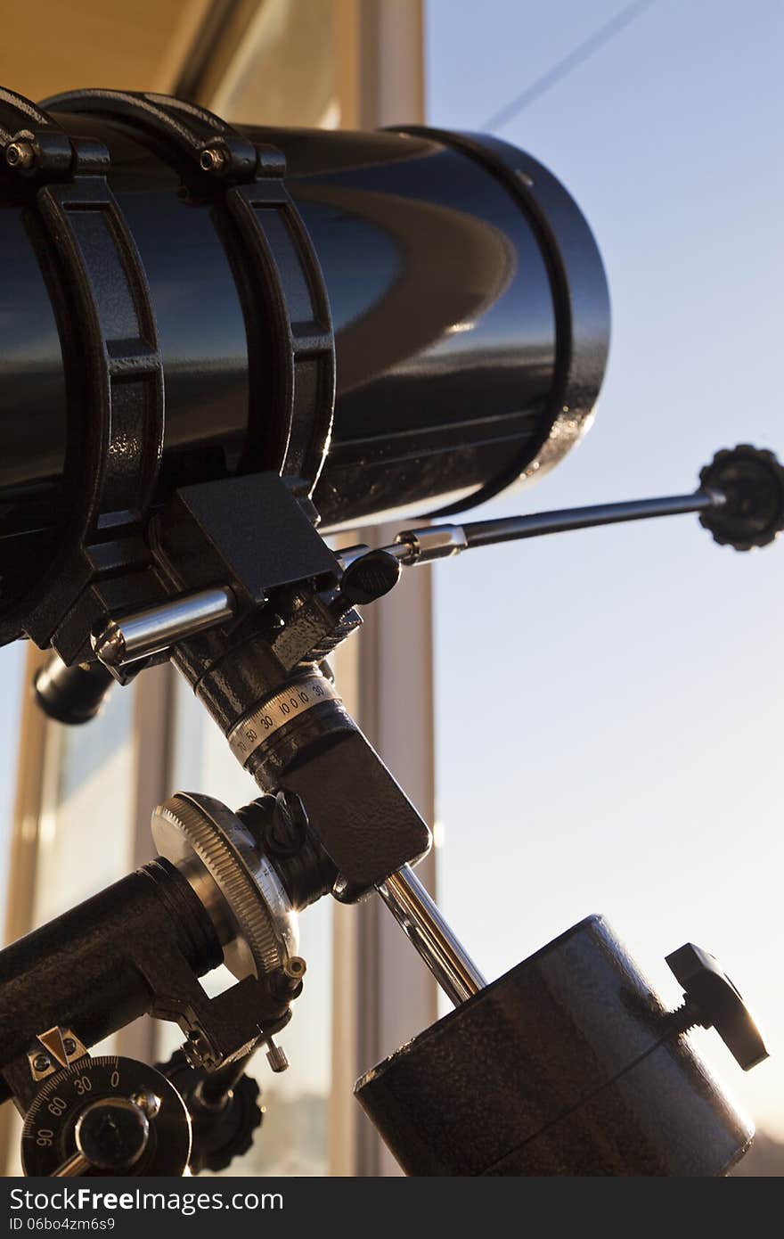 The telescope looks out of the window waiting for stars