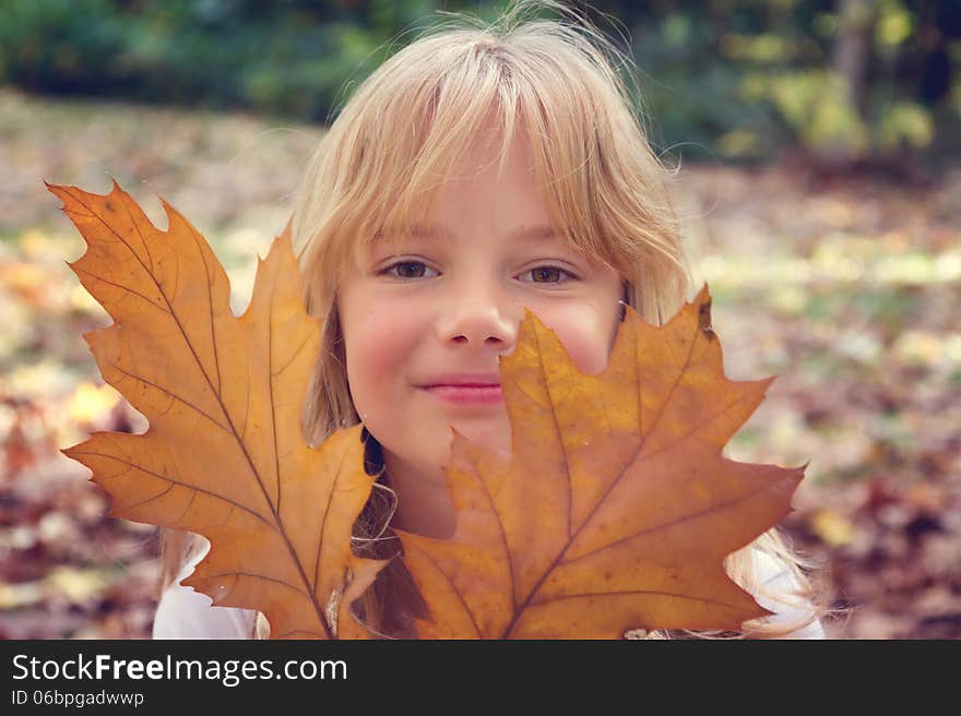 A little girl lying in autumn leaves. A little girl lying in autumn leaves.