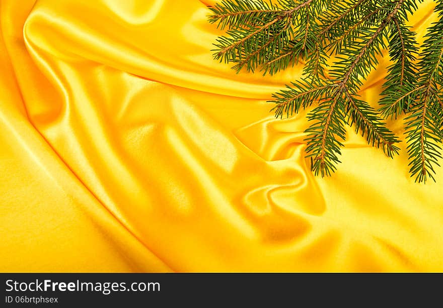 Pine tree branch over yellow silk. Pine tree branch over yellow silk