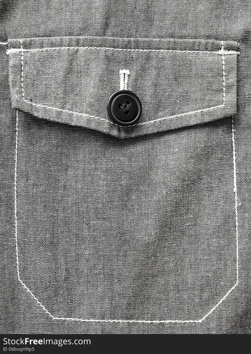 Gray jacket pocket closed on black button. Gray jacket pocket closed on black button