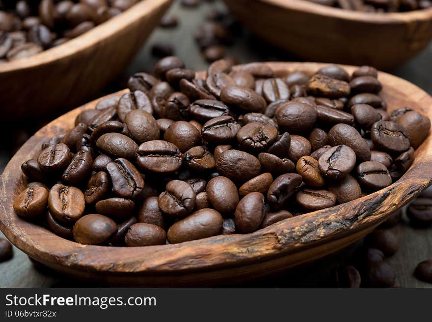 Coffee beans in a wooden bowl, close-up, selective focus