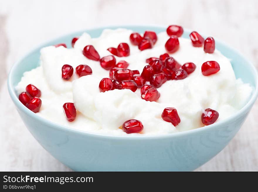 Homemade yogurt with pomegranate seeds, close-up