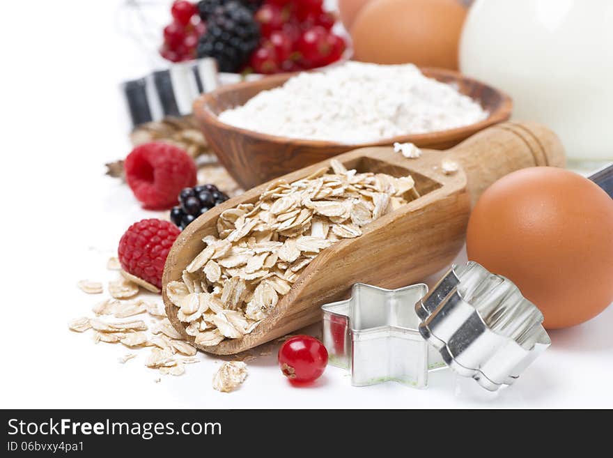 Oatmeal, flour, milk, eggs and fresh berries - the ingredients for baking cookies, close-up