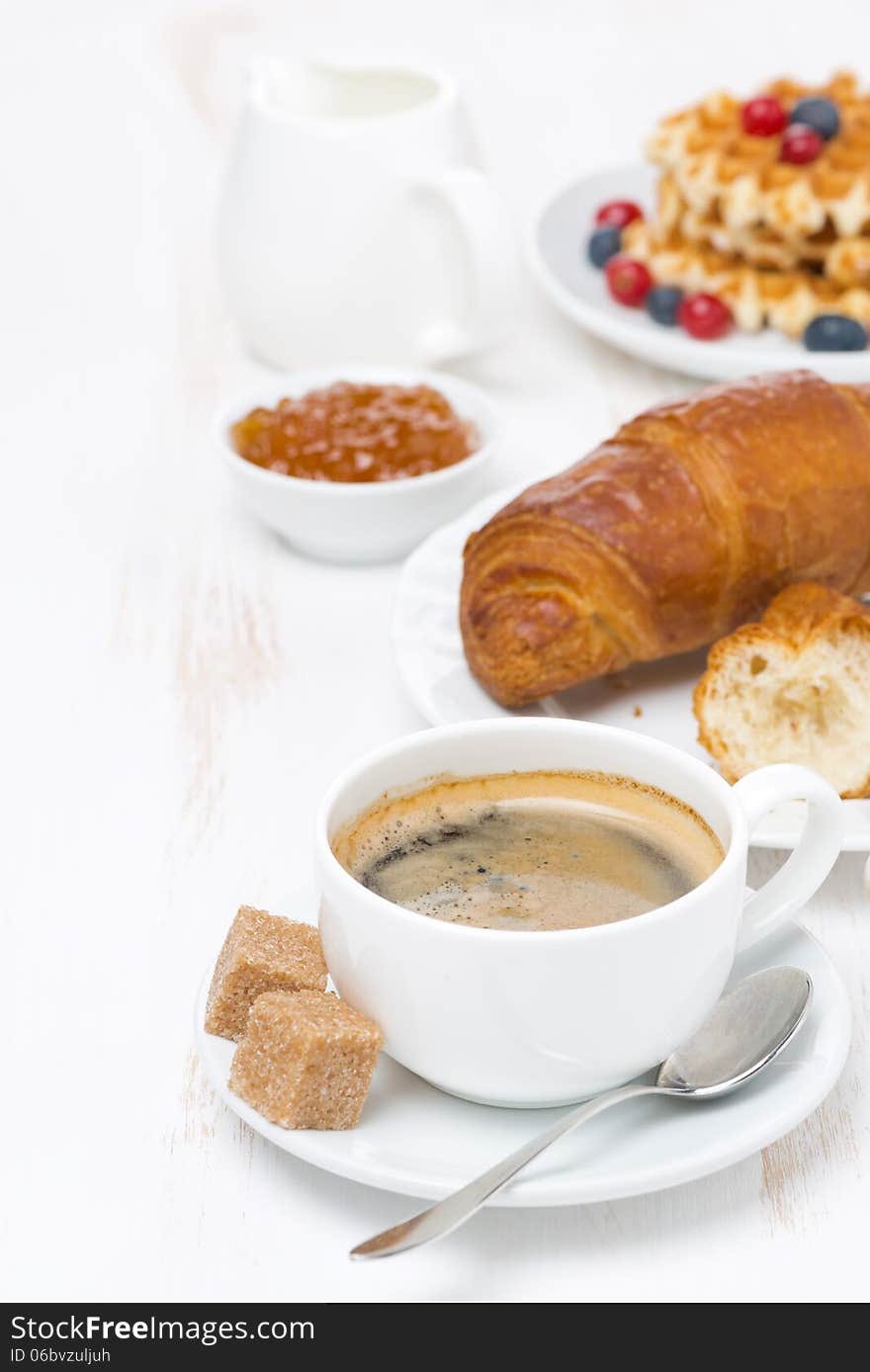 Sweet breakfast with black coffee, croissants, orange jam