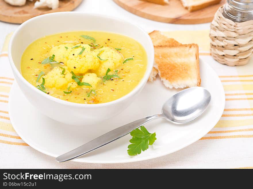 Cauliflower soup with curry and cream in a bowl