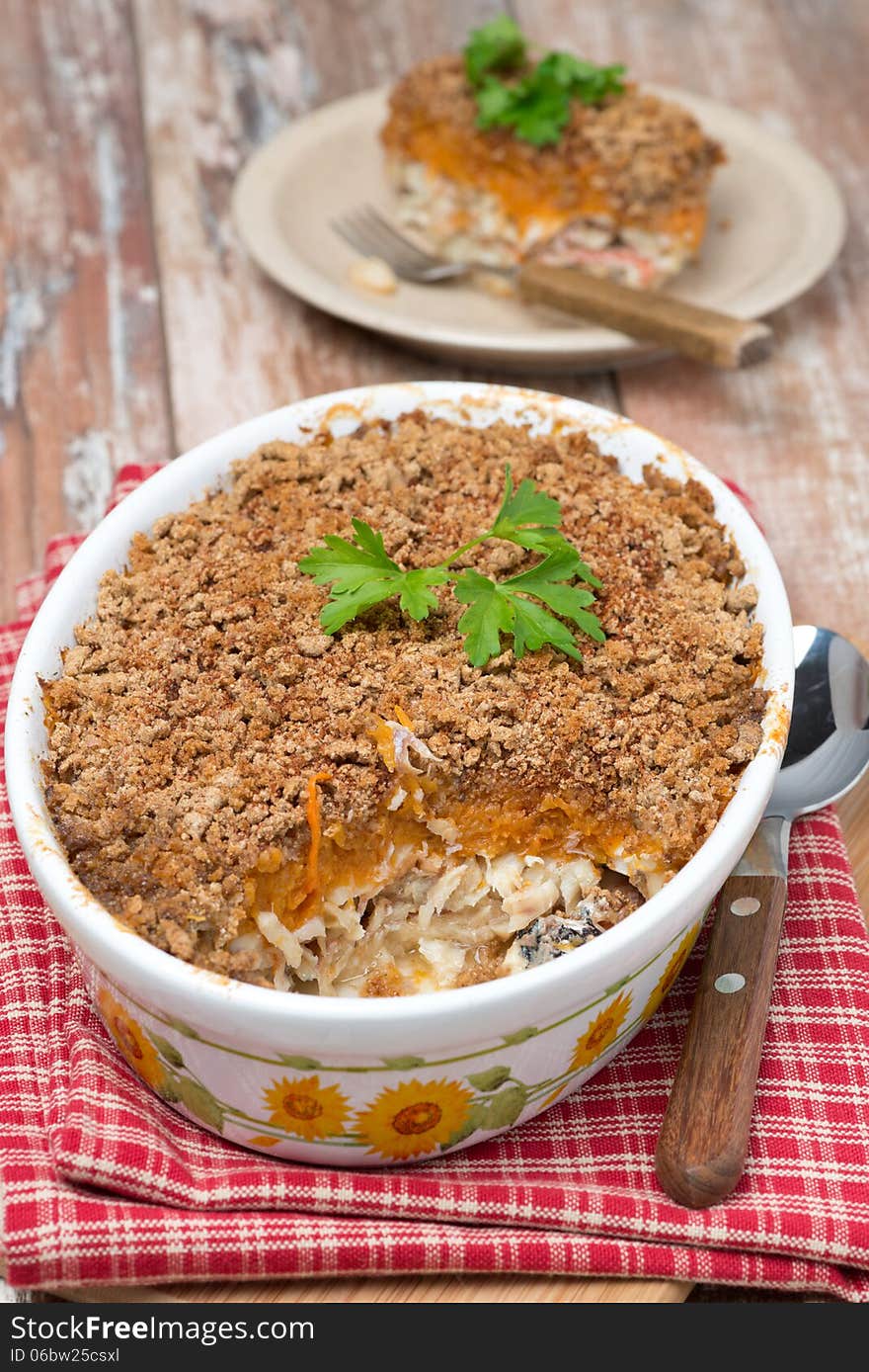 Gratin with fish and pumpkin in a ceramic form, vertical