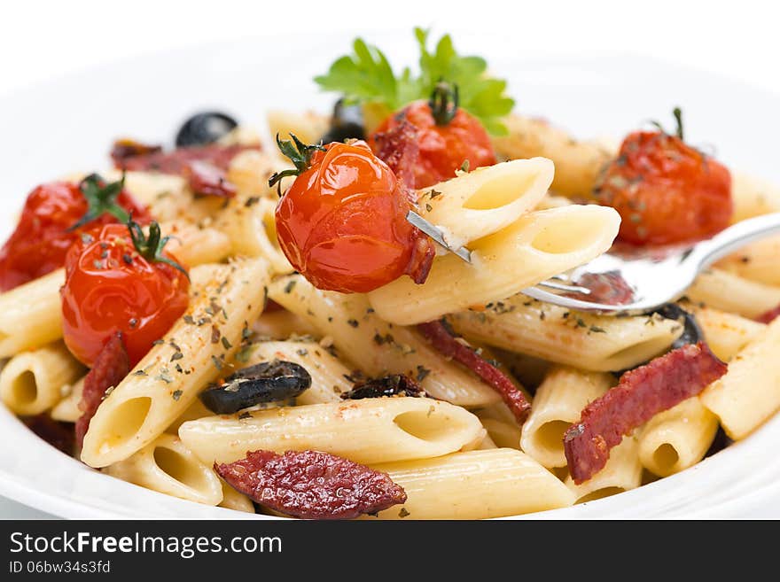 Pasta with sausage, cherry tomatoes and olives, close-up