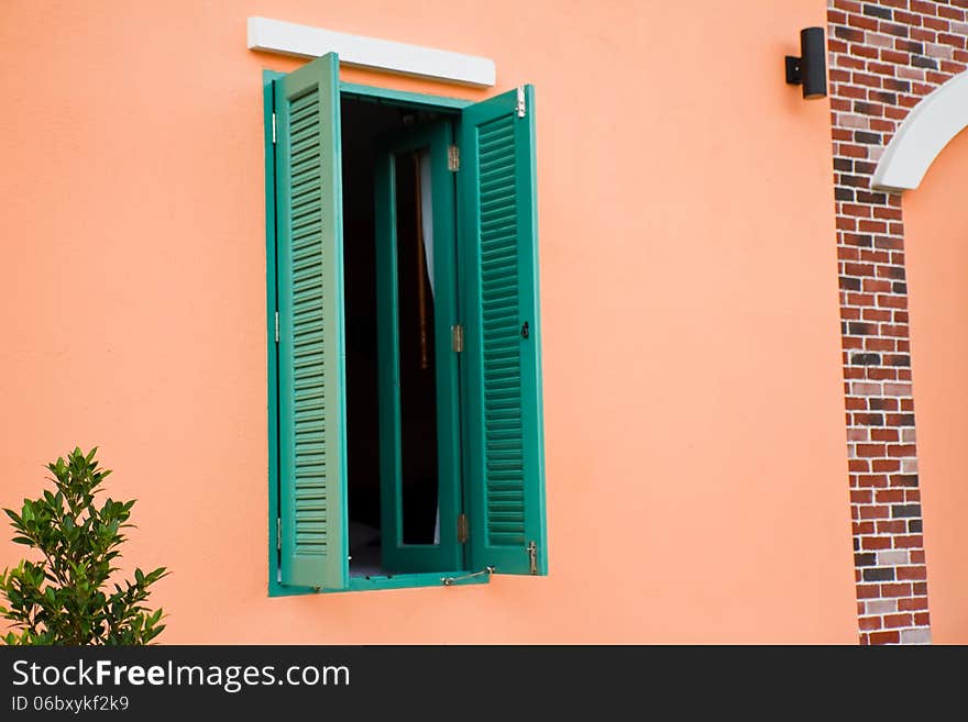 Green window is open on pink wall. Green window is open on pink wall