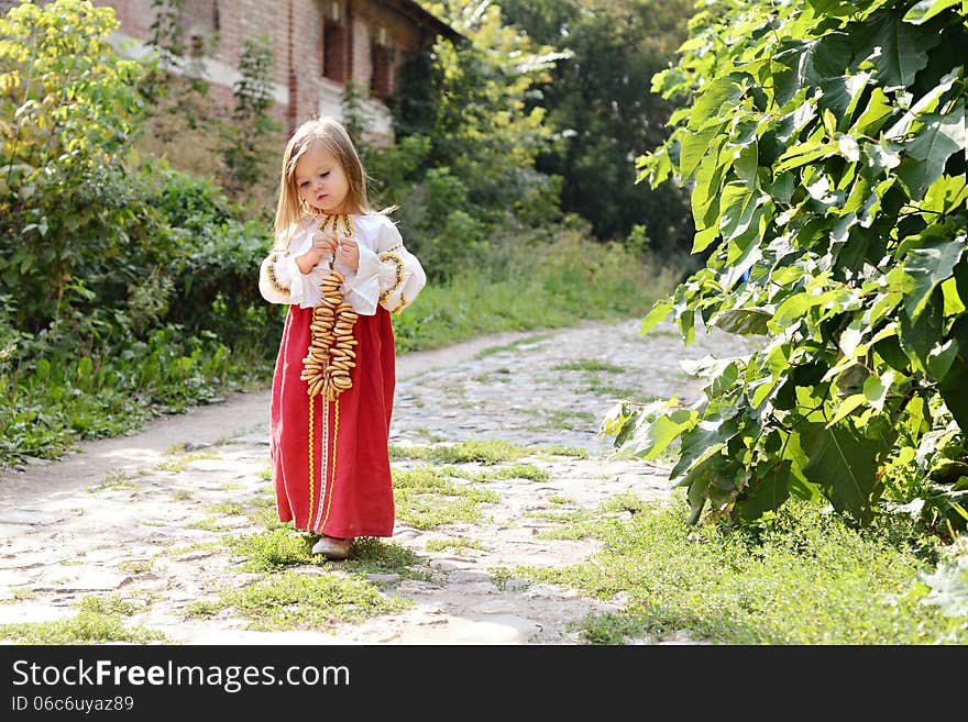 Little girl in russian national costume goes on road. Little girl in russian national costume goes on road