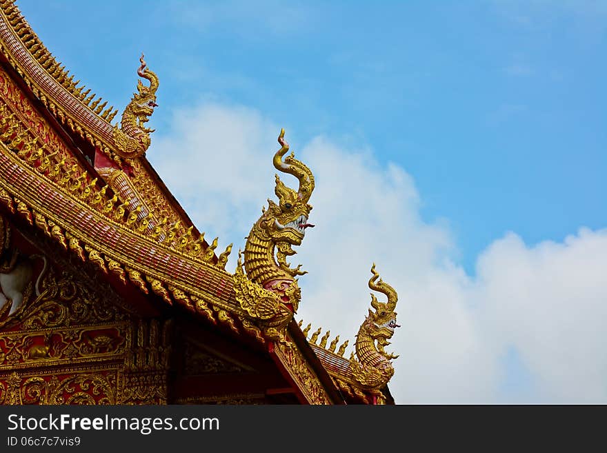 Roof style of thai temple that decorate with naga and blue sky background