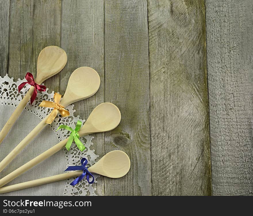 Four spoons with colorful bows on wooden background. Four spoons with colorful bows on wooden background