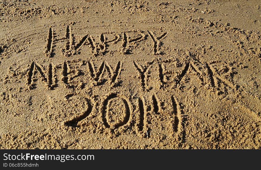 The words Happy New Year 2014 written in sand on the beach. The words Happy New Year 2014 written in sand on the beach