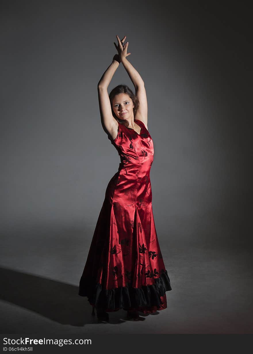 Young woman dancing flamenco, studio shot, gray background