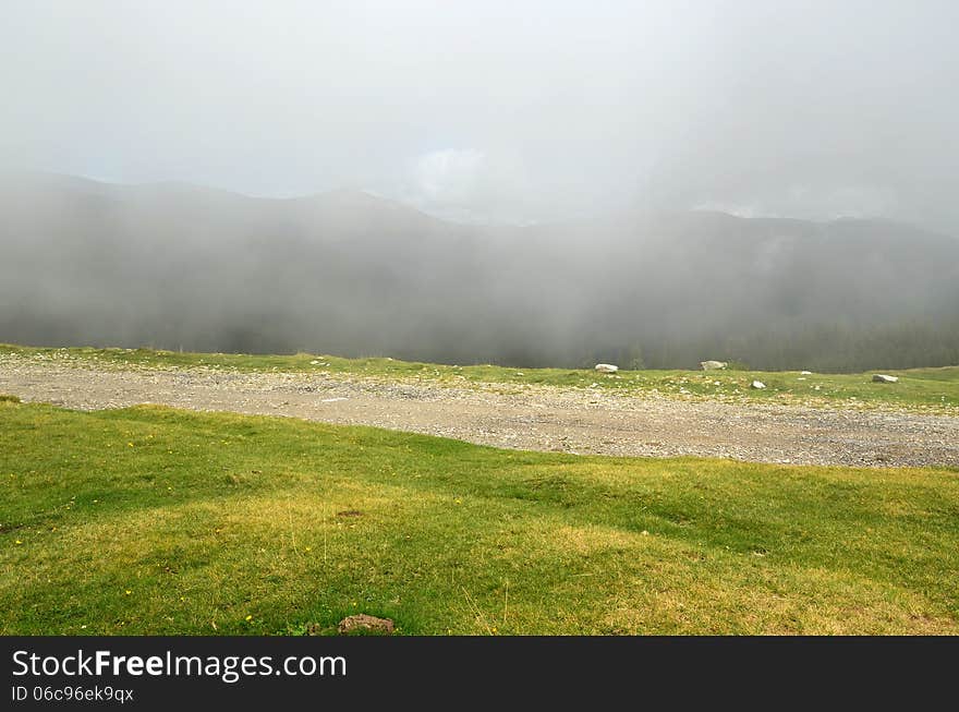 Storm is coming and clouds seem to connect with the ground. The shot was taken on Transalpina road, in Parang Mountains, a Group of the Carpathian Mountains in Romania. Storm is coming and clouds seem to connect with the ground. The shot was taken on Transalpina road, in Parang Mountains, a Group of the Carpathian Mountains in Romania.