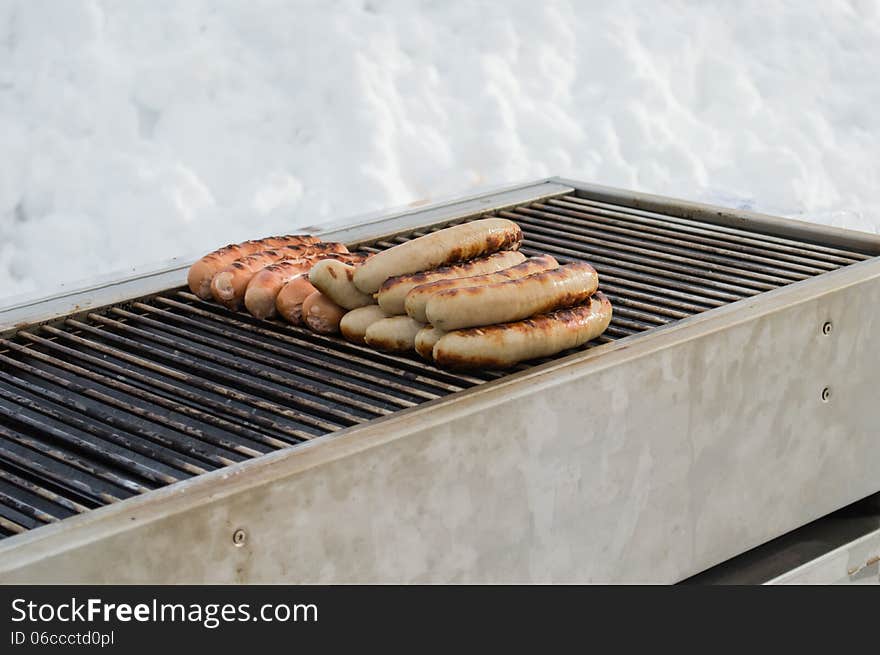 Grilled traditional German sausage hot dog on a grill during a winter day. Grilled traditional German sausage hot dog on a grill during a winter day