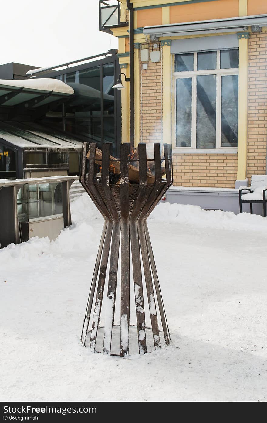 Brazier filled up with snow near a house. Brazier filled up with snow near a house