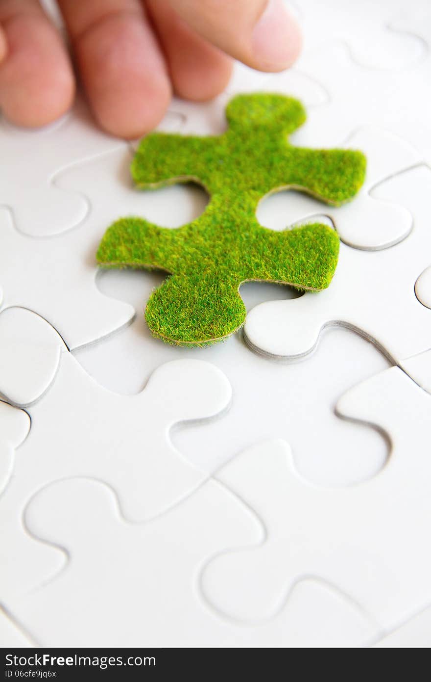 Hand holding a green puzzle piece