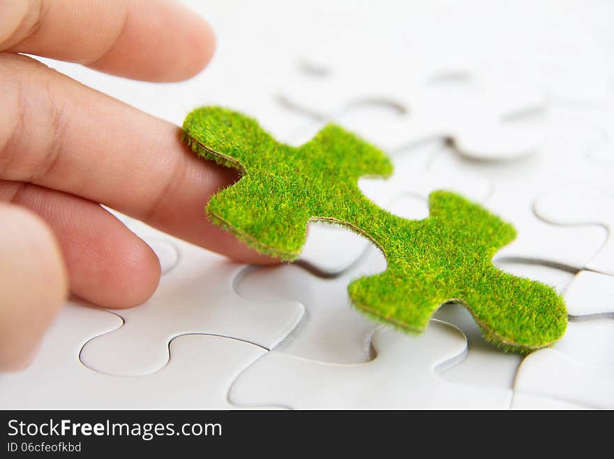 Hand holding a green puzzle piece