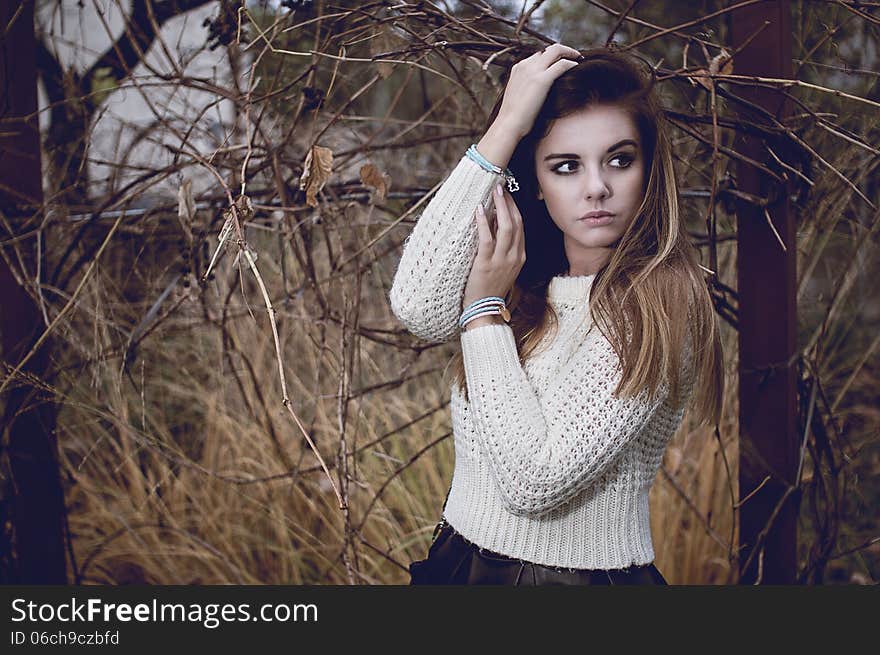 Young woman portrait with silver jewelary on hand in white sweater. Young woman portrait with silver jewelary on hand in white sweater