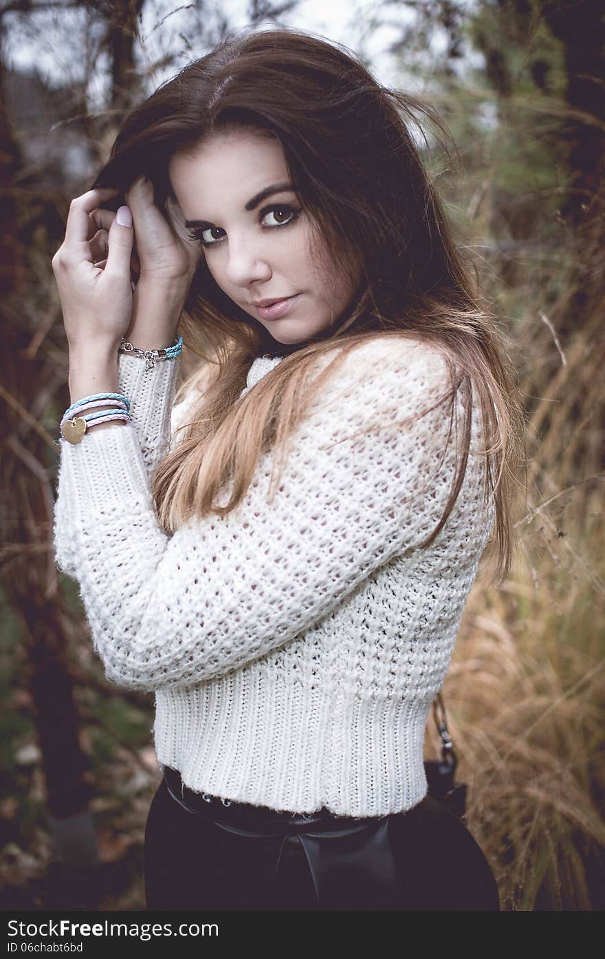 Young woman portrait with silver jewelary on hand in white sweater. Young woman portrait with silver jewelary on hand in white sweater