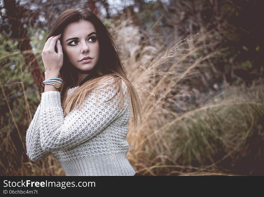 Young woman with silver jewelary on hand in white sweater. Young woman with silver jewelary on hand in white sweater