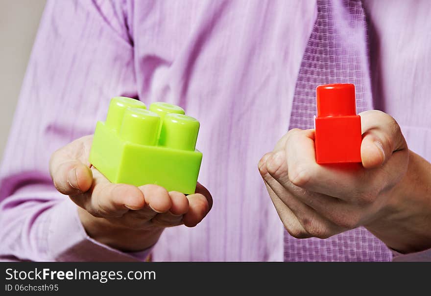 Young man is playing with multicolored toy blocks. Young man is playing with multicolored toy blocks.