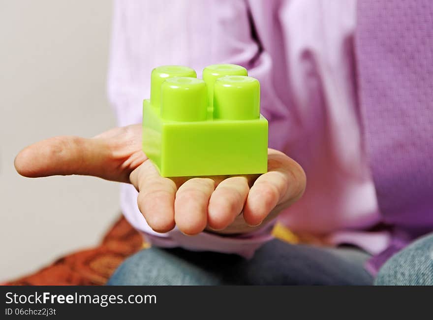 Young man is playing with multicolored toy blocks. Young man is playing with multicolored toy blocks.