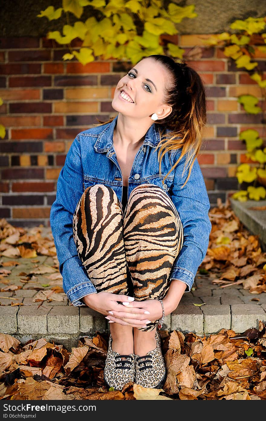 Beautiful brunette sitting on a step with a pretty smile. Beautiful brunette sitting on a step with a pretty smile