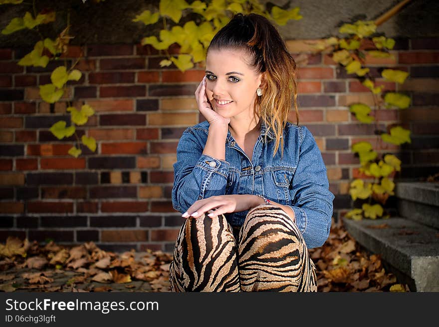 Beautiful brunette sitting on a step with a pretty smile. Beautiful brunette sitting on a step with a pretty smile