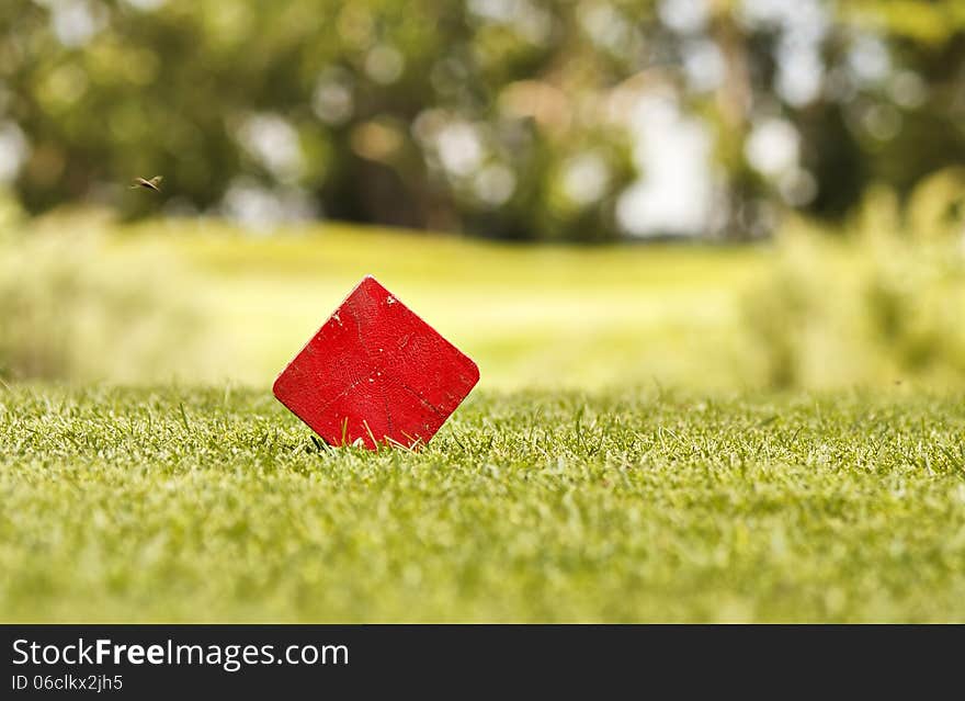 Red block of wood on a golf coarse