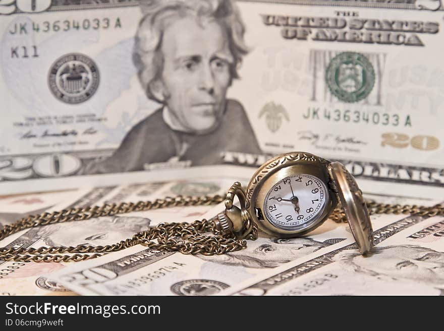 Pocket watch lie on dollars. watch and chain