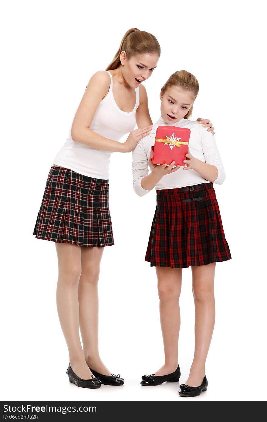 Portrait of sisters with a gift box on white background