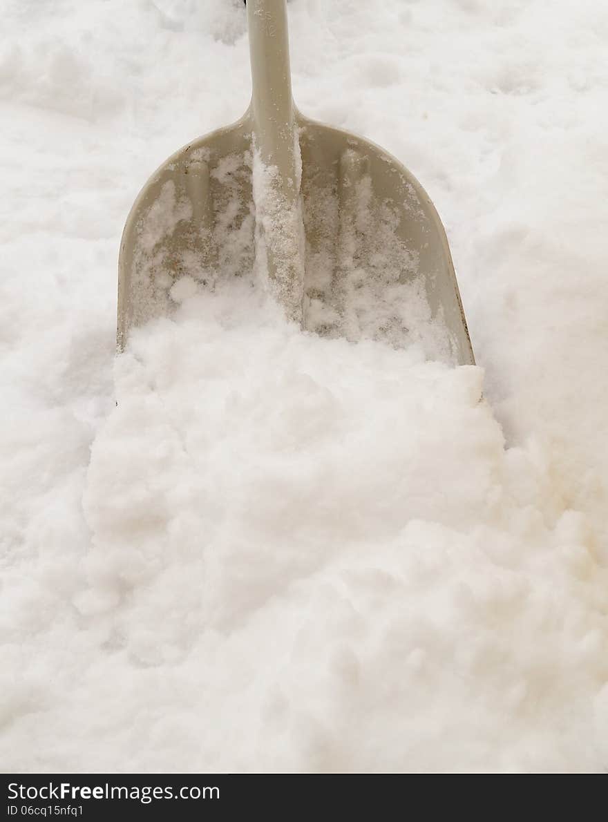 An isolated gray snow shovel removes fresh snow after a winter storm.