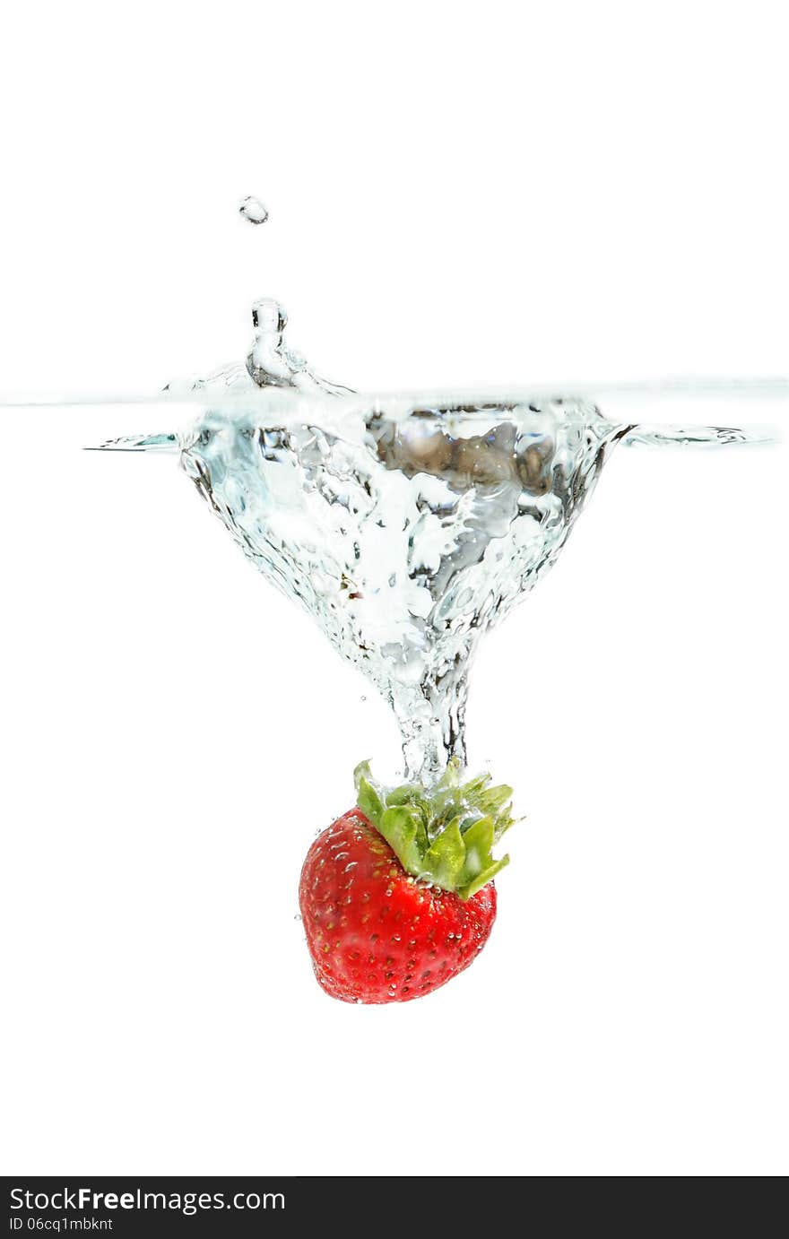 Fresh strawberry falling into the water making splash. Fresh strawberry falling into the water making splash