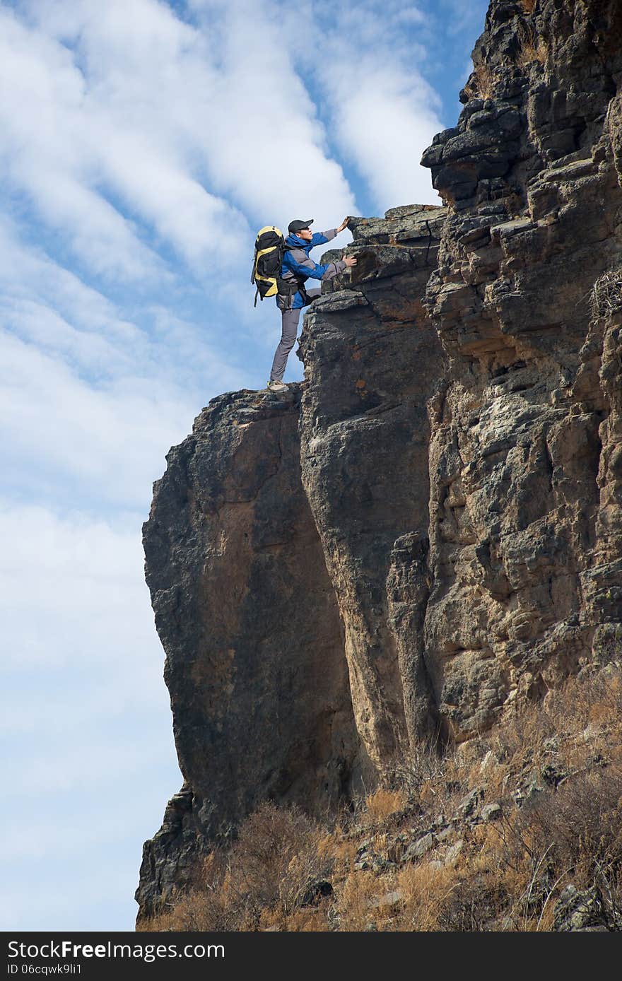 Man climbing on the rock on the outdoor sky