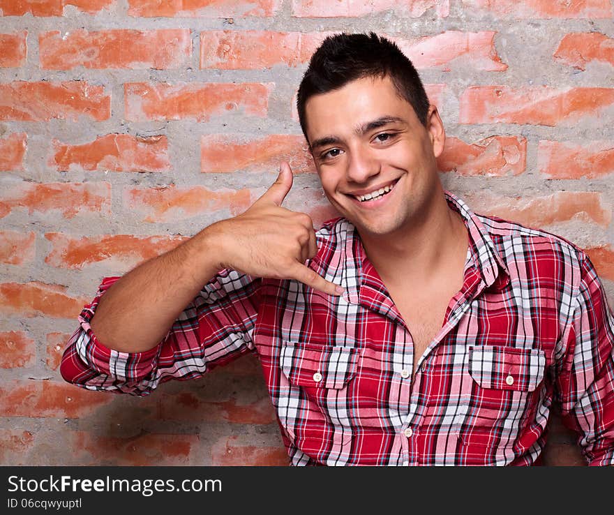 Smiling young man gesturing with hand. Smiling young man gesturing with hand.