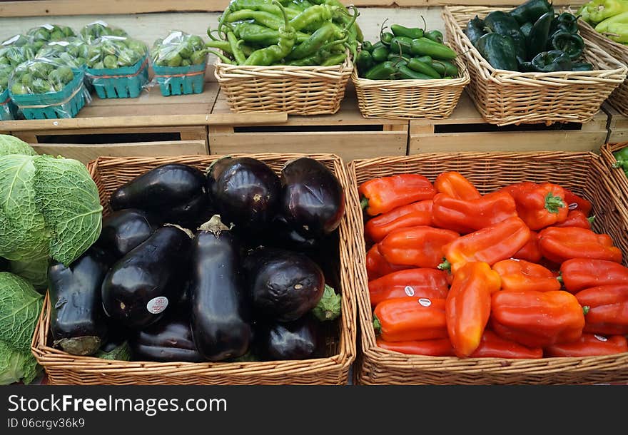 Fresh vegetables for sale at a farmers market: red, green, Serrano and habanero chili peppers, eggplant, cabbage and Brussels sprouts. Fresh vegetables for sale at a farmers market: red, green, Serrano and habanero chili peppers, eggplant, cabbage and Brussels sprouts.